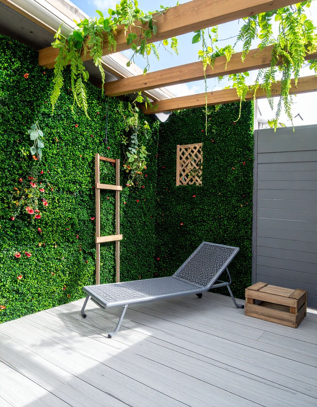 Terrasse avec chaise longue, murs végétalisés et poutres en bois