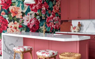 Cuisine audacieuse avec îlot rose corail, mur à grand motif floral et sol à damier