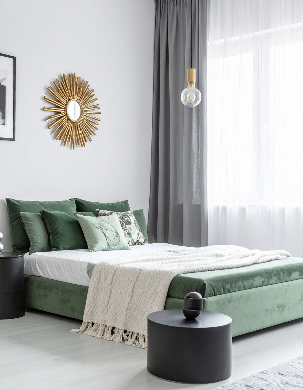 Chambre avec lit en velours vert, plaid blanc cassé et miroir soleil doré