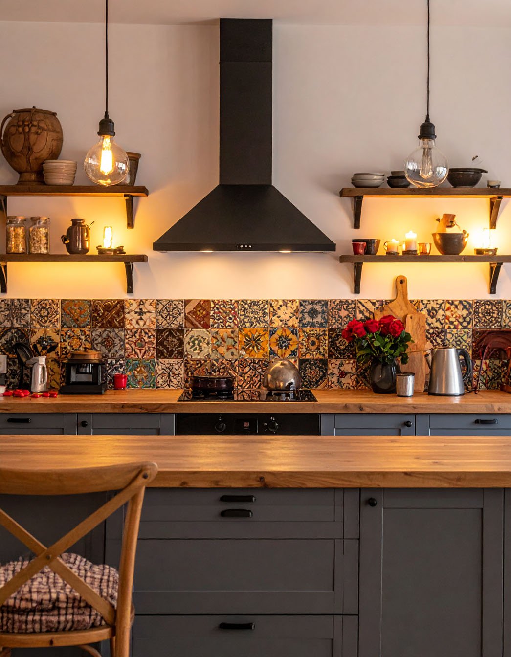 Cuisine avec meubles bas gris foncé, plan de travail en bois et crédence en carreaux de ciment colorés