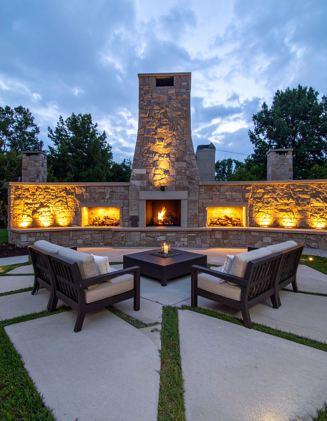 Terrasse avec cheminée extérieure en briques et salon de jardin en résine tressée