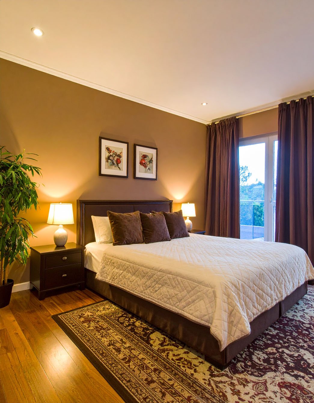 Chambre aux tons marron avec lit, coussins en velours et tapis à motifs orientaux