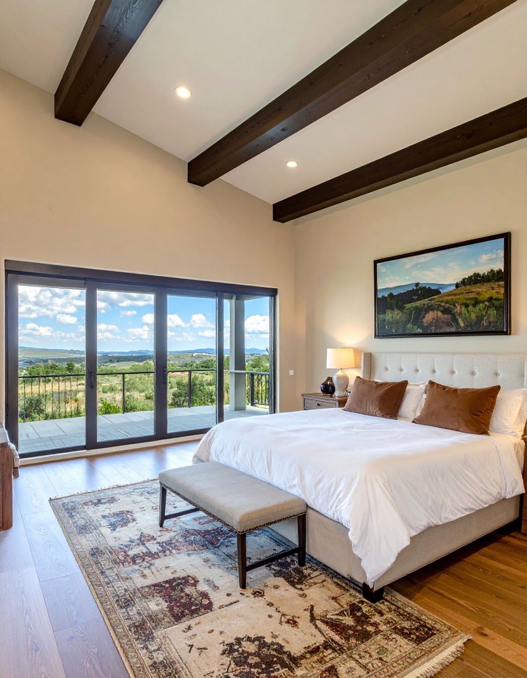 Chambre avec lit en bois, literie blanche, tapis en peau de mouton et accès à une terrasse