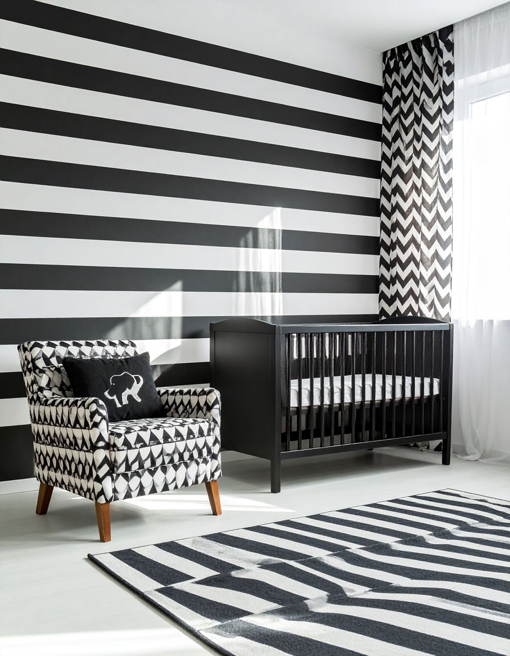 Chambre d'enfant avec mur à larges rayures noires et blanches, fauteuil et tapis assortis