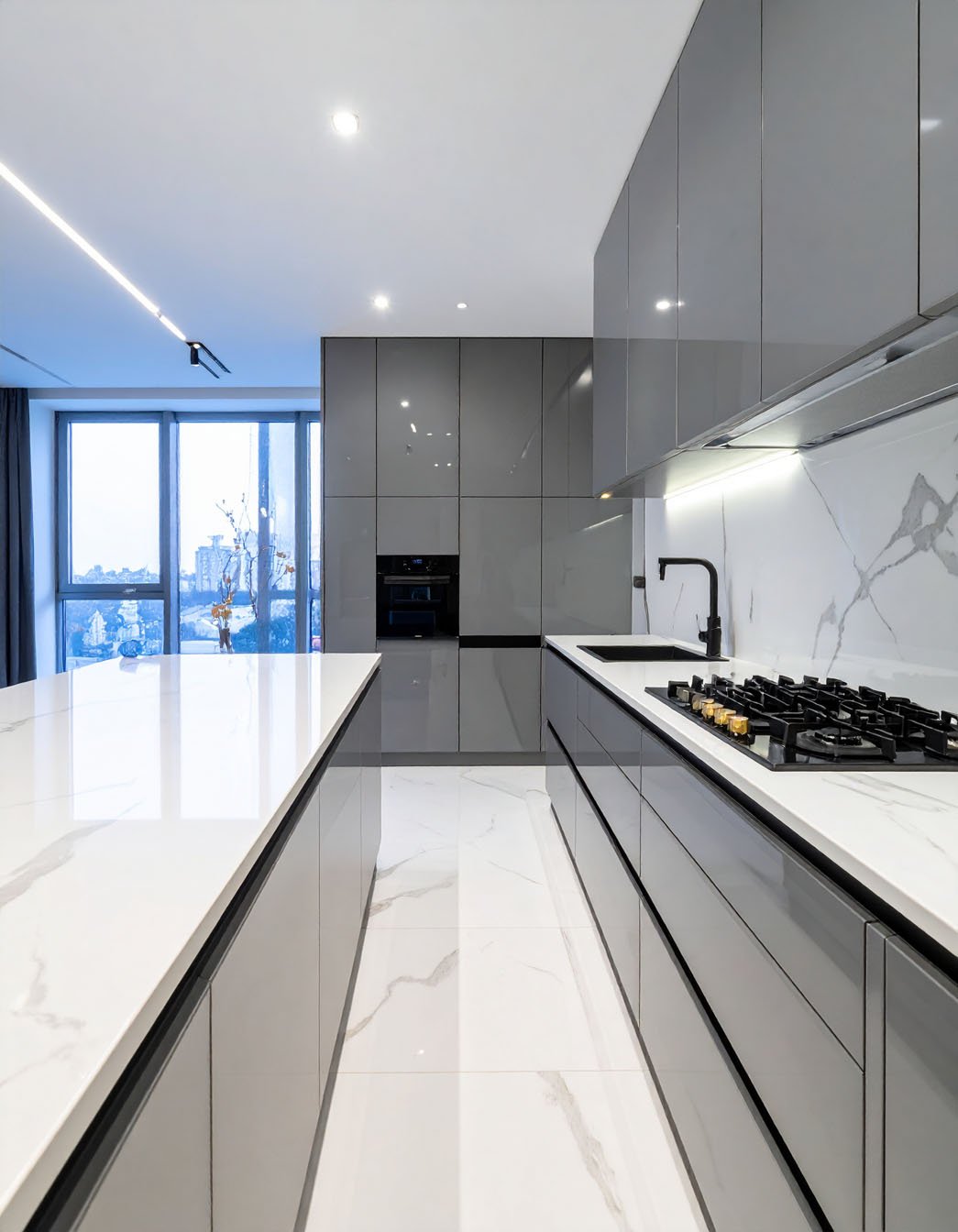 Cuisine moderne avec meubles gris laqué, îlot blanc et grande baie vitrée