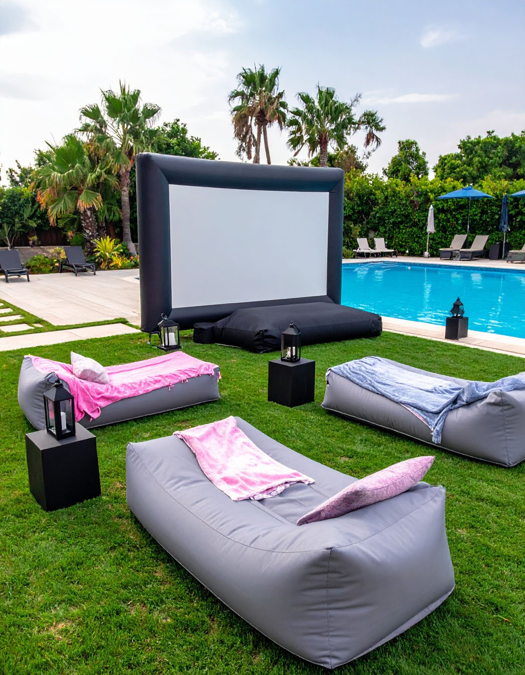 Cinéma en plein air avec écran gonflable géant, chaises longues et guirlandes lumineuses