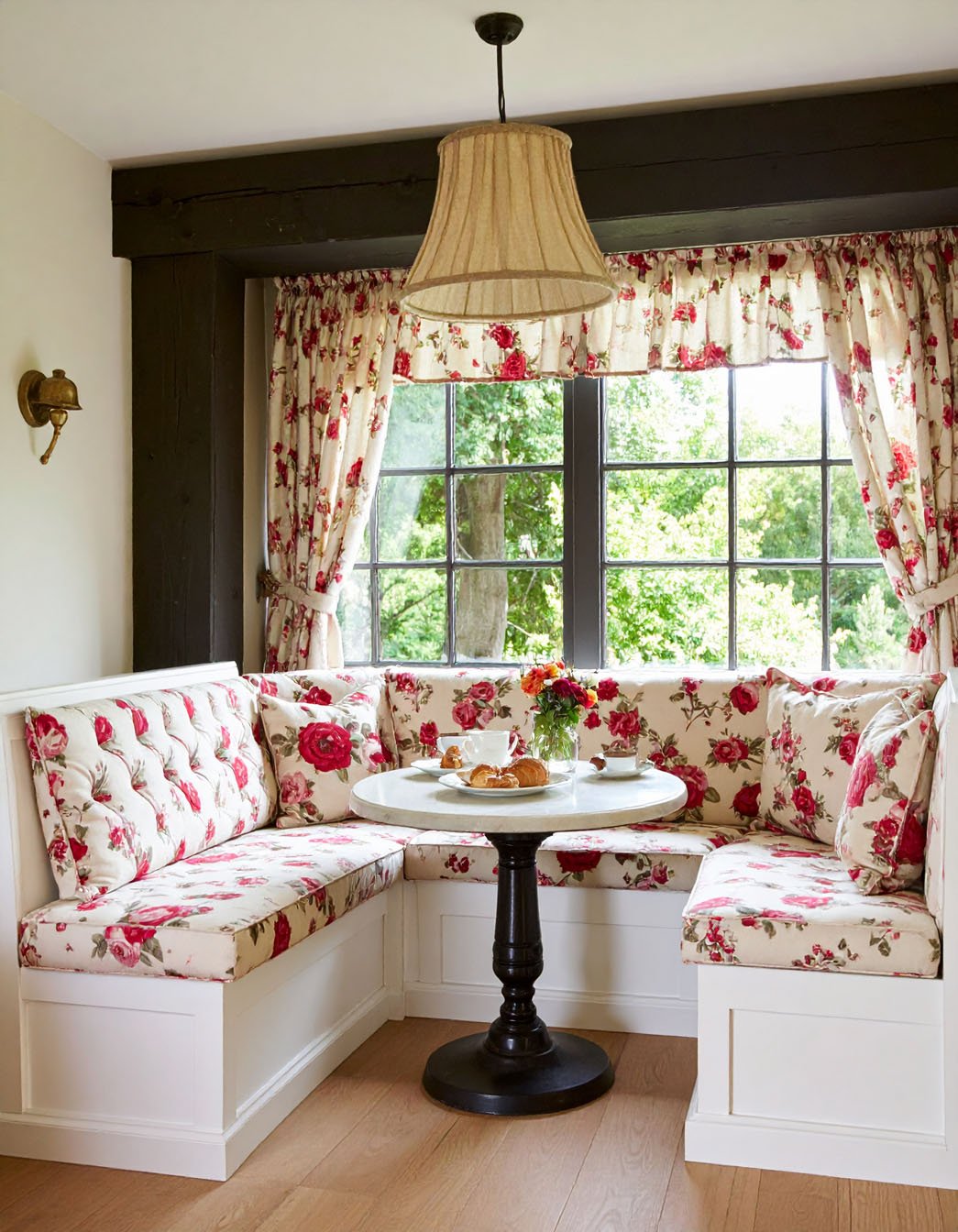 Coin repas d'angle de style cottage avec banquette et rideaux à motifs de roses