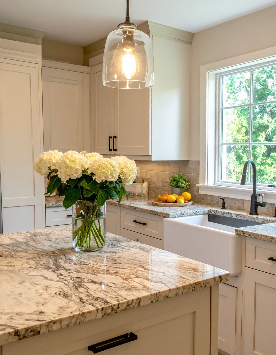 Îlot de cuisine en granit moucheté avec évier timbre d'office et bouquet d'hortensias blancs