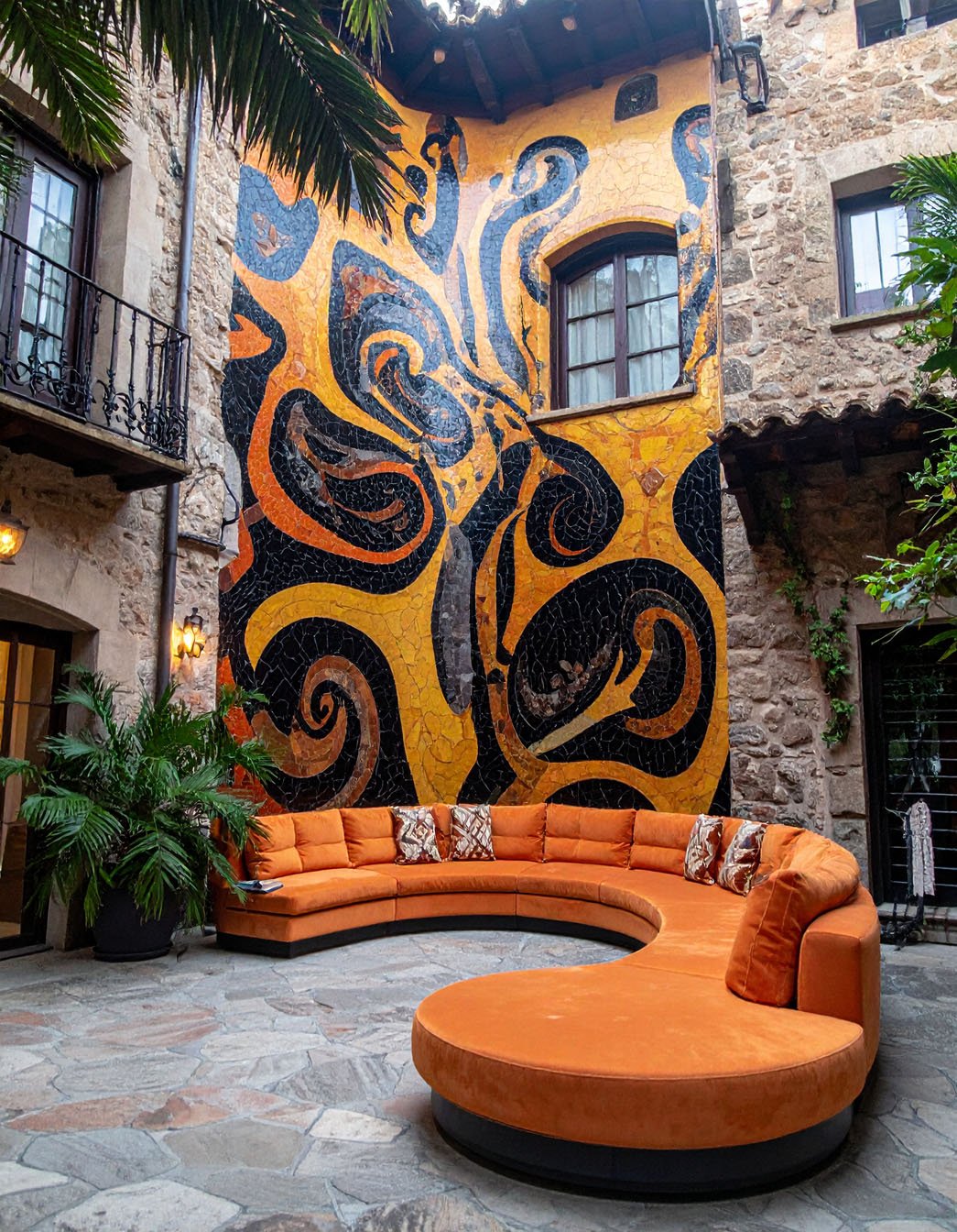 Patio carrelé avec mur en briques et sculptures décoratives colorées
