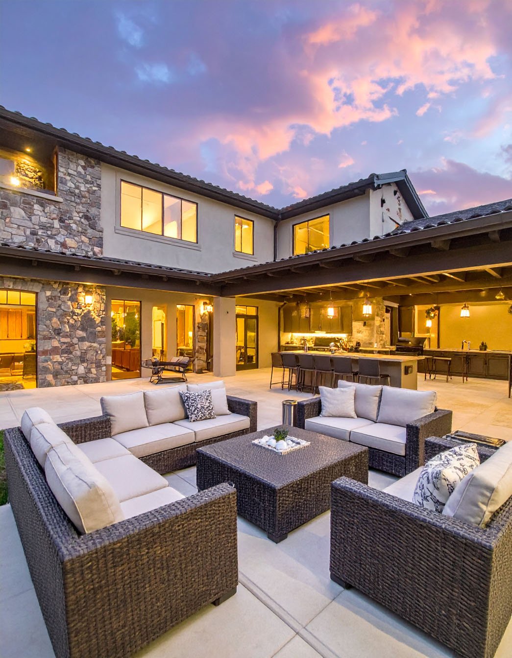 Patio moderne avec foyer extérieur, canapés et éclairage intégré au sol