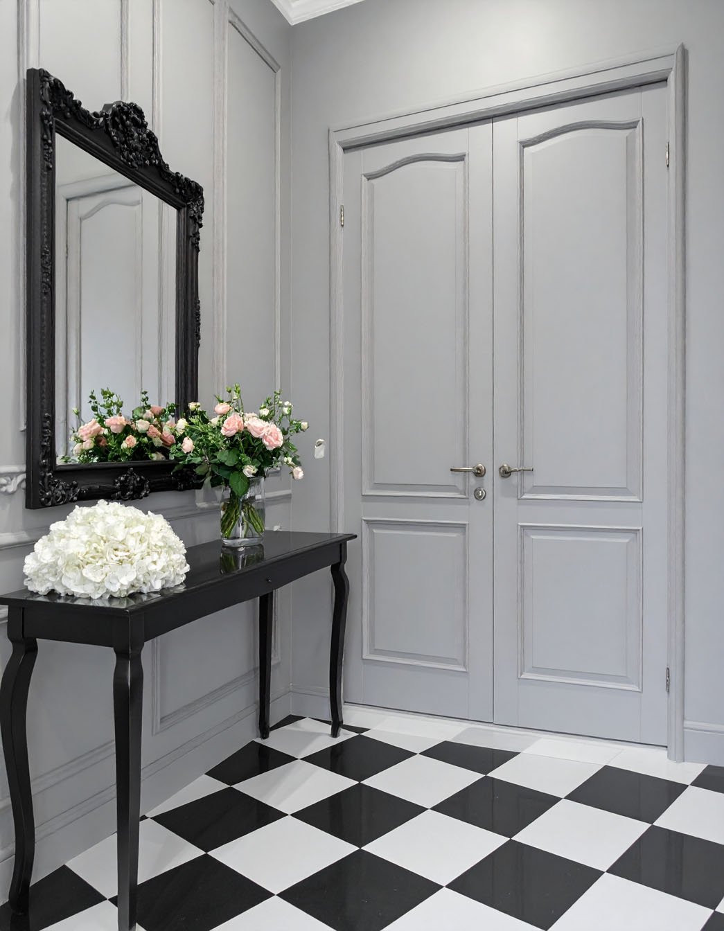 Entrée avec murs gris, console noire, miroir orné et sol à damier noir et blanc