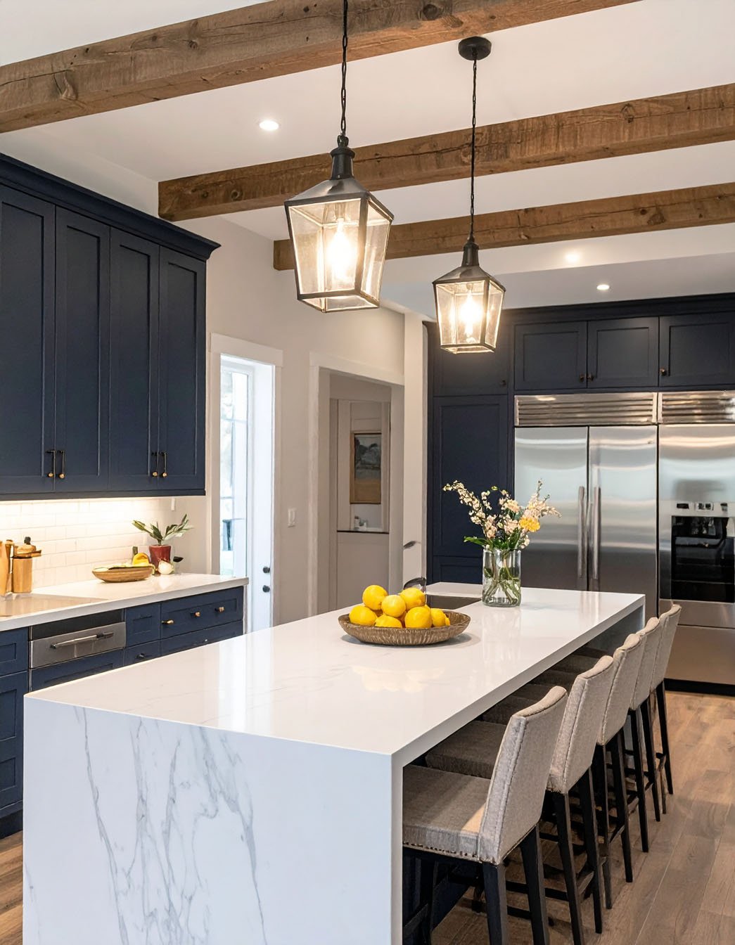 Cuisine bleu marine avec grand îlot effet marbre blanc et suspensions lanternes