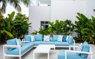 Terrasse avec salon de jardin en aluminium blanc et coussins gris, table basse assortie