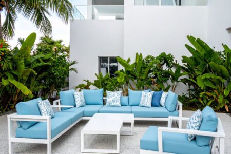Terrasse avec salon de jardin en aluminium blanc et coussins gris, table basse assortie