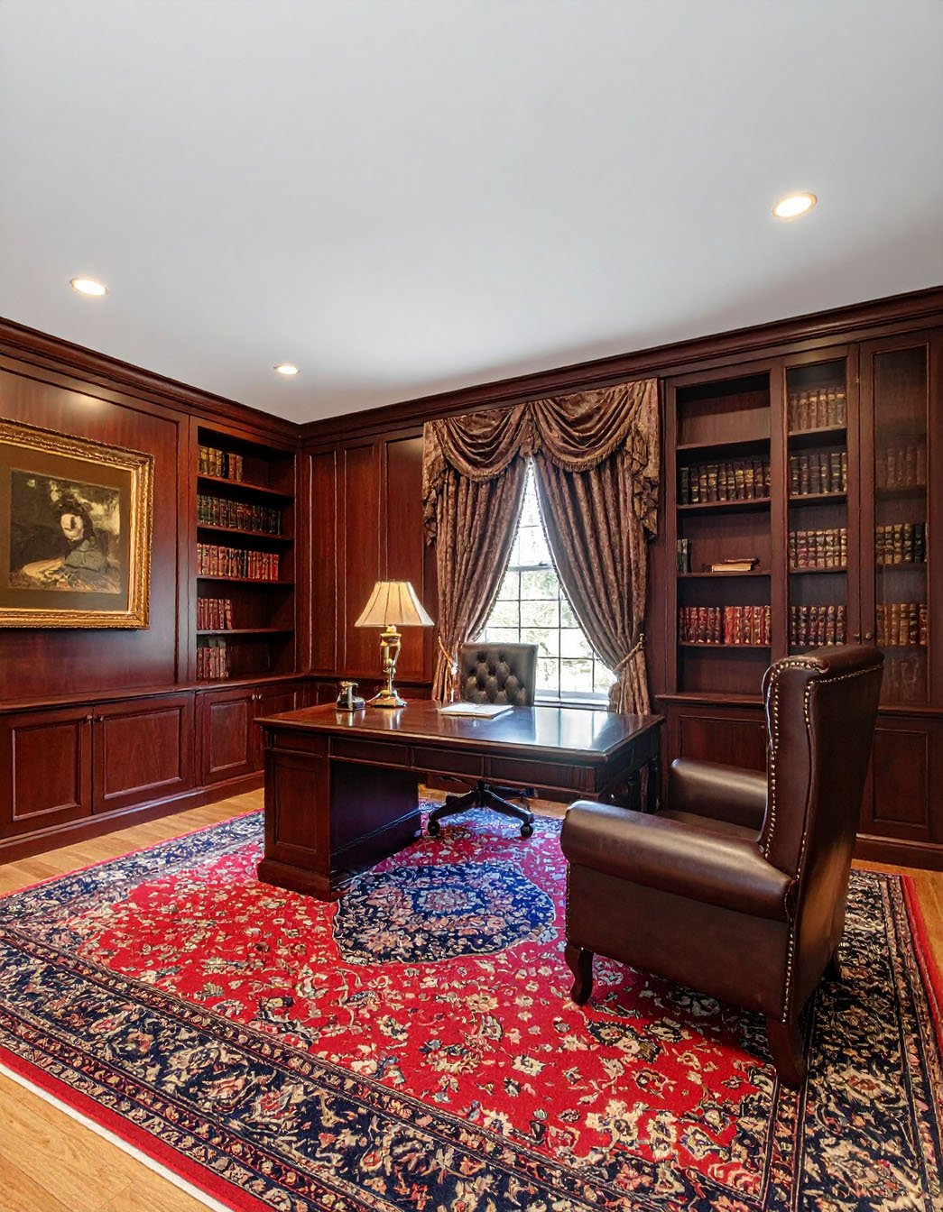 Bureau classique avec murs verts, grand bureau en bois et bibliothèque intégrée