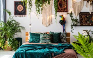 Chambre bohème avec lit en bois, tentures murales, et une profusion de plantes suspendues et au sol