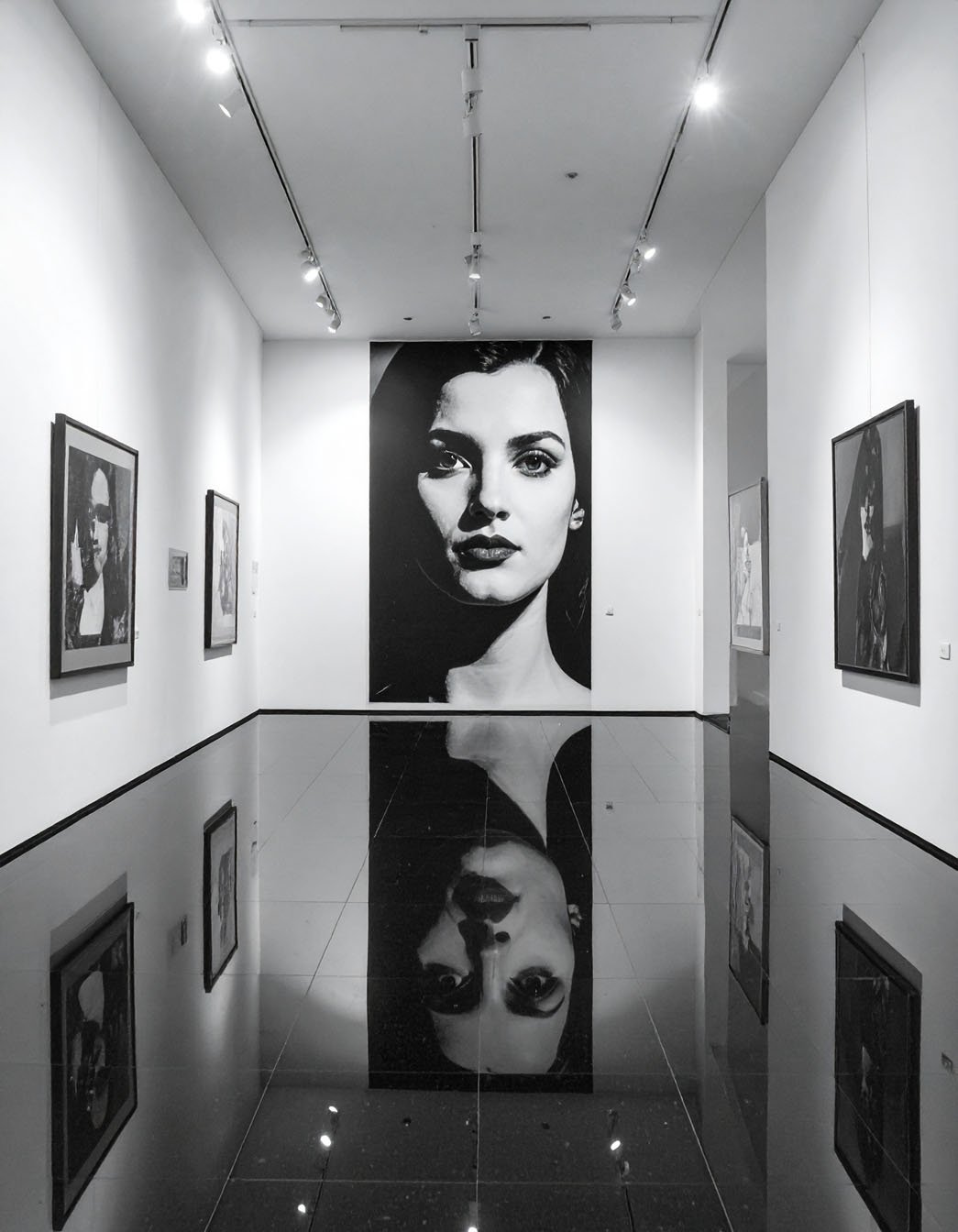 Galerie d'art avec grand portrait en noir et blanc et sol noir réfléchissant