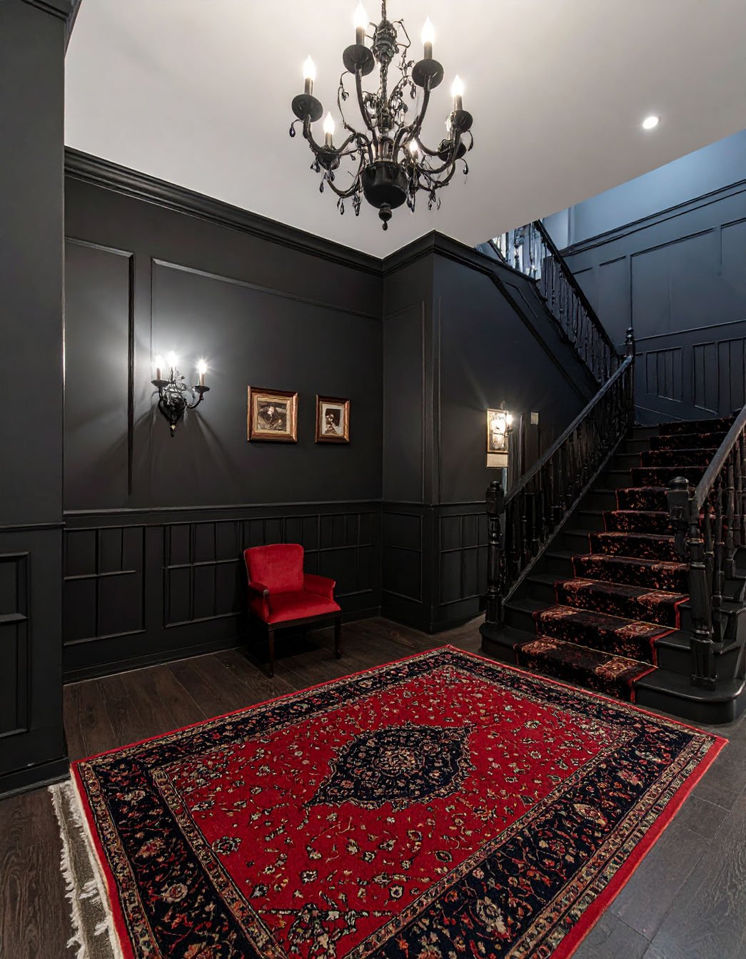 Couloir gothique avec murs noirs, sol en damier noir et blanc et lustre en cristal