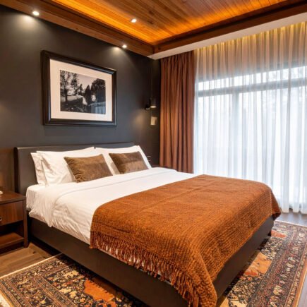 Chambre avec murs foncés, plafond en lattes de bois, plaid couleur rouille et tapis persan