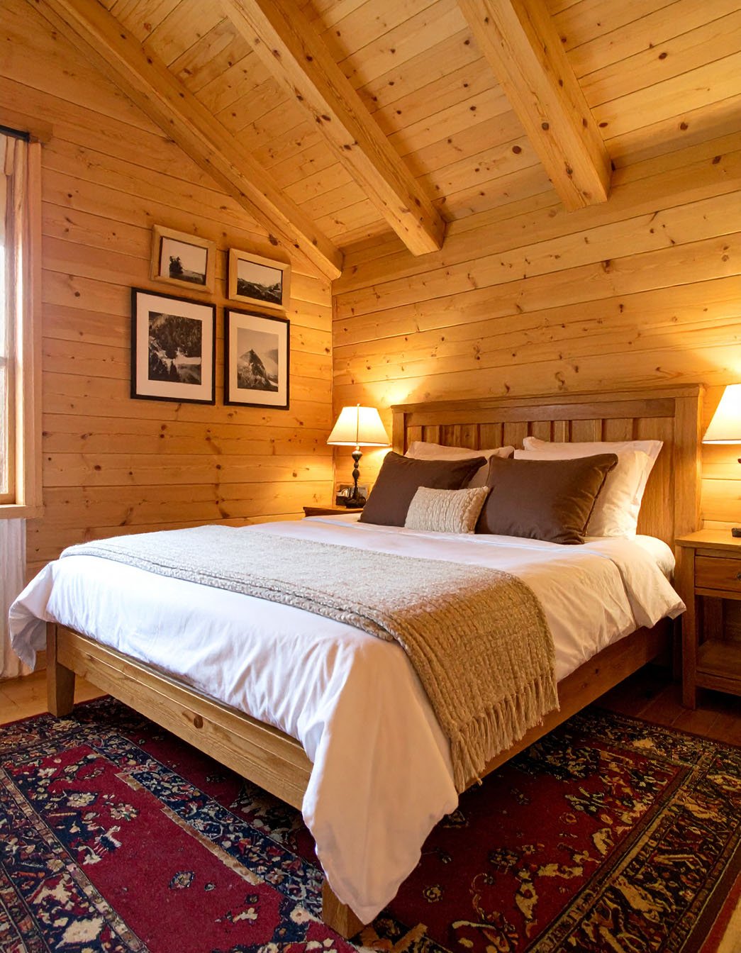 Chambre de chalet lambrissée en pin avec lit et commode en bois clair
