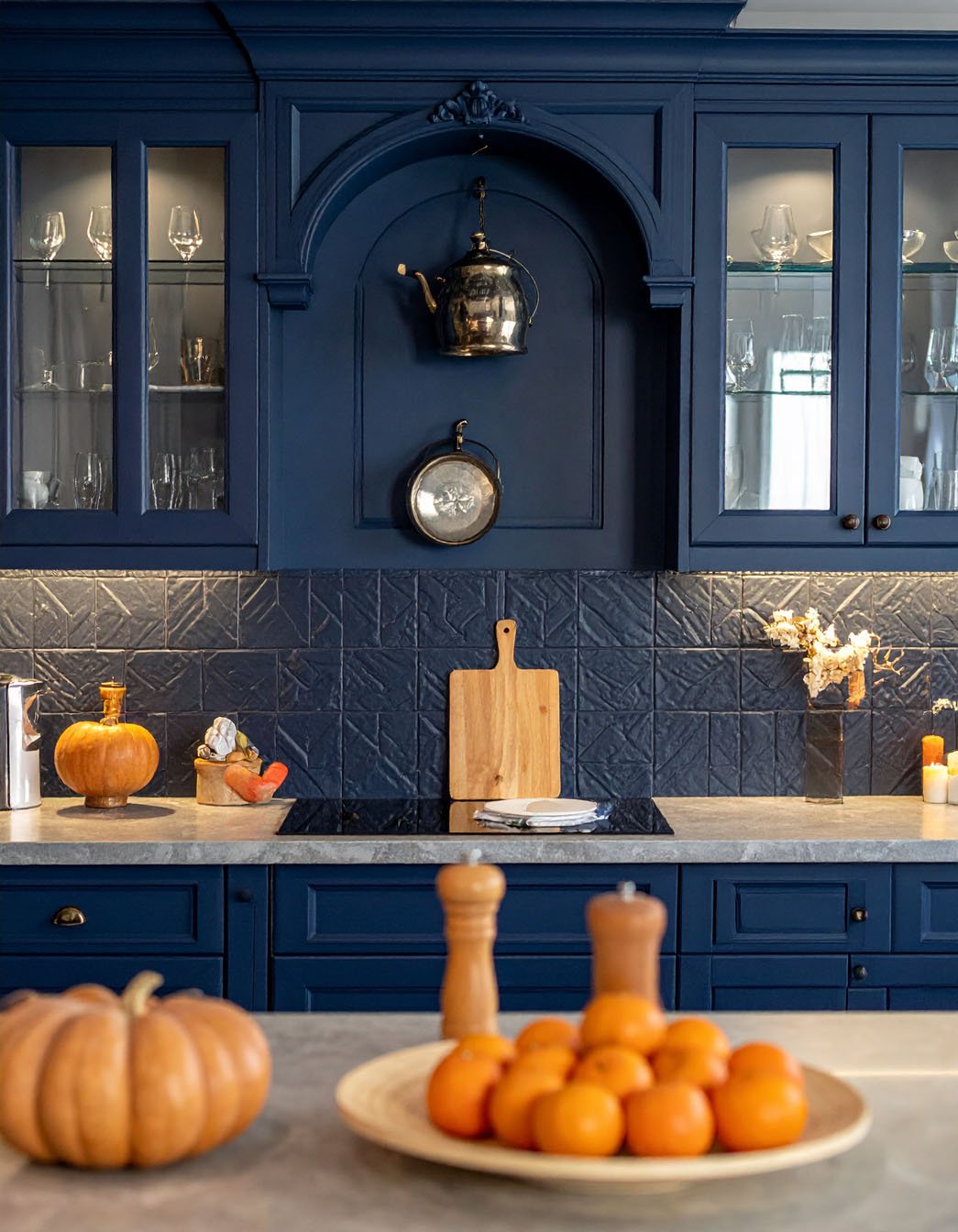 Cuisine bleu marine avec crédence en carreaux texturés, niche décorative et citrouilles