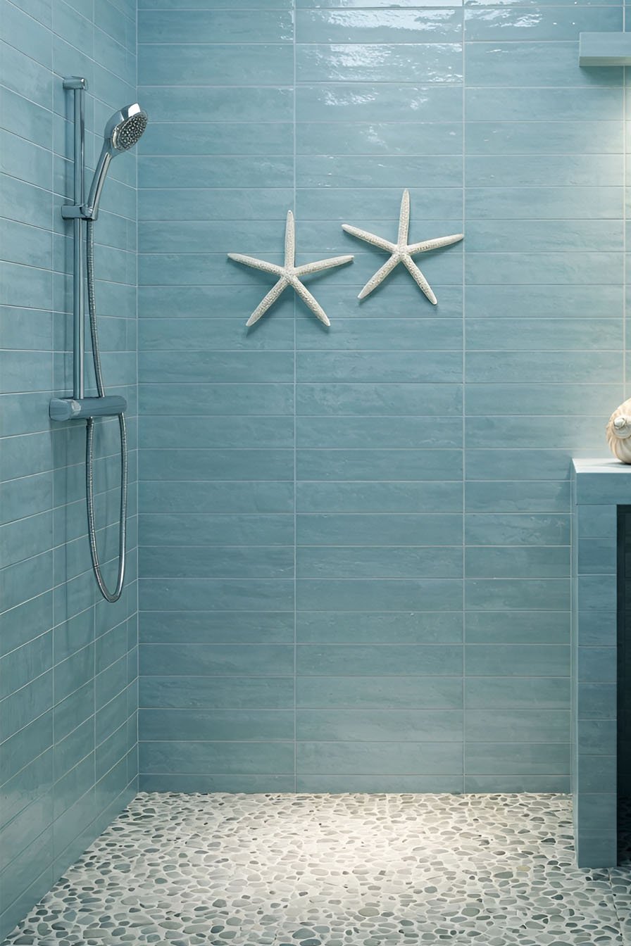 Douche avec murs en carrelage bleu clair, sol en galets ronds et décoration murale d'étoiles de mer blanches