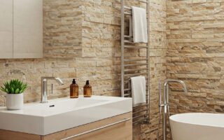 Salle de bain avec murs en pierre naturelle, vasque moderne et baignoire îlot