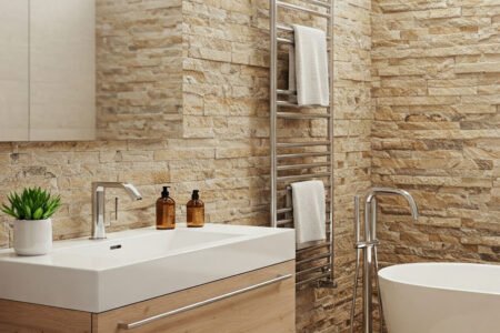 Salle de bain avec murs en pierre naturelle, vasque moderne et baignoire îlot