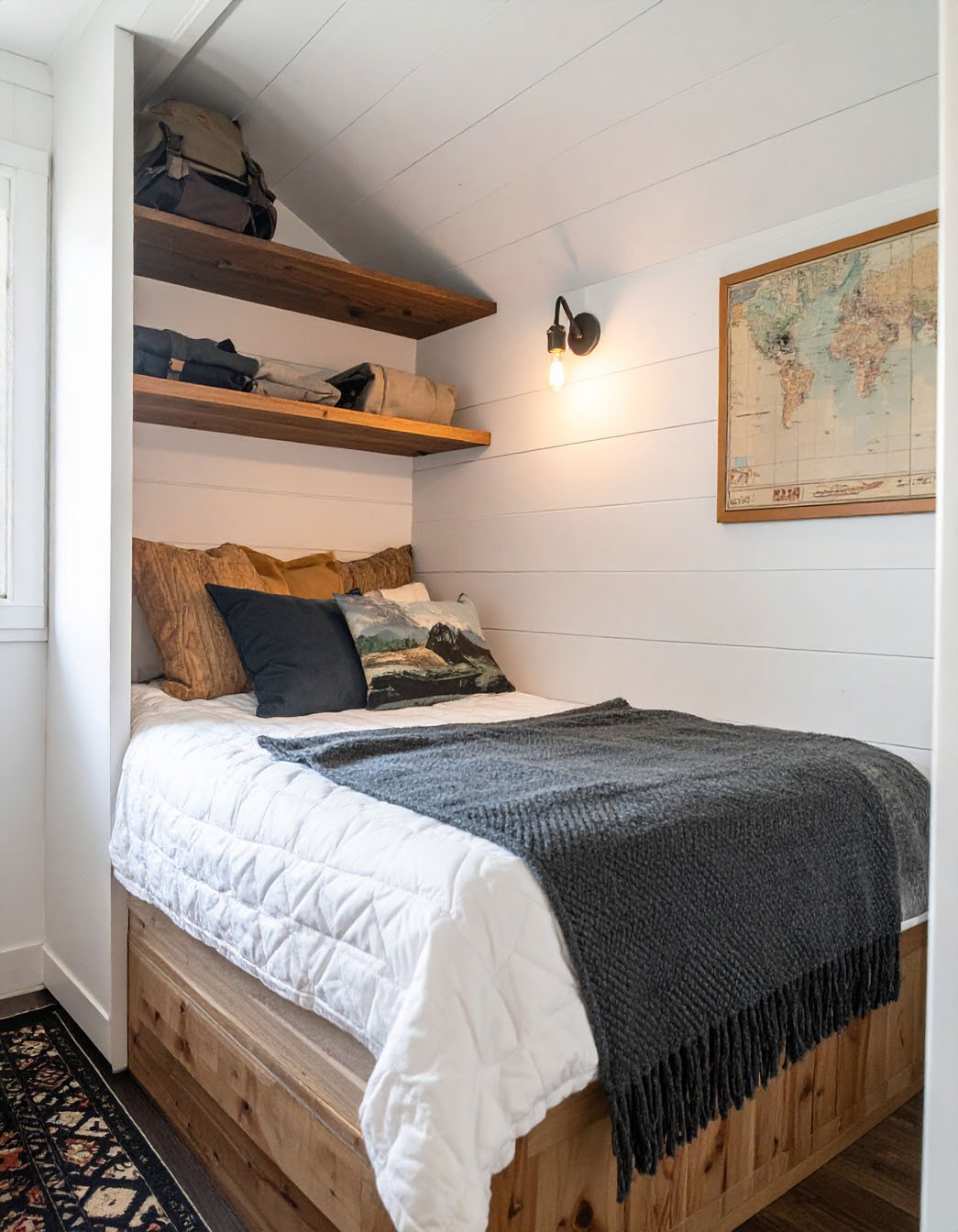 Chambre de chalet avec lit en bois, couvre-lit à carreaux et murs en planches de bois