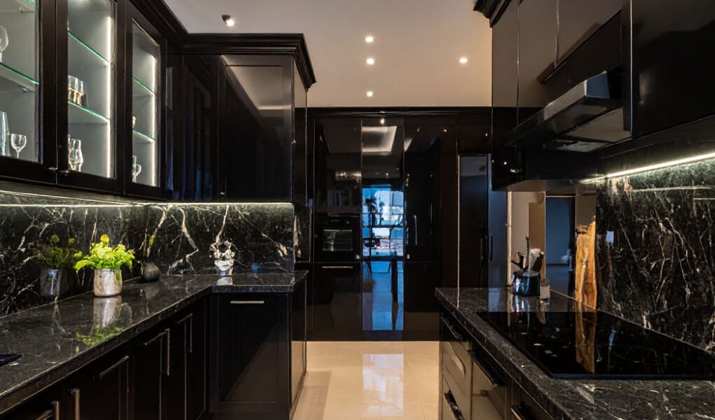 Cuisine luxueuse noire avec plans de travail en marbre noir et lustre en cristal