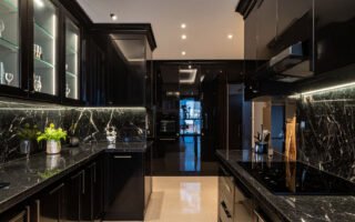 Cuisine luxueuse noire avec plans de travail en marbre noir et lustre en cristal