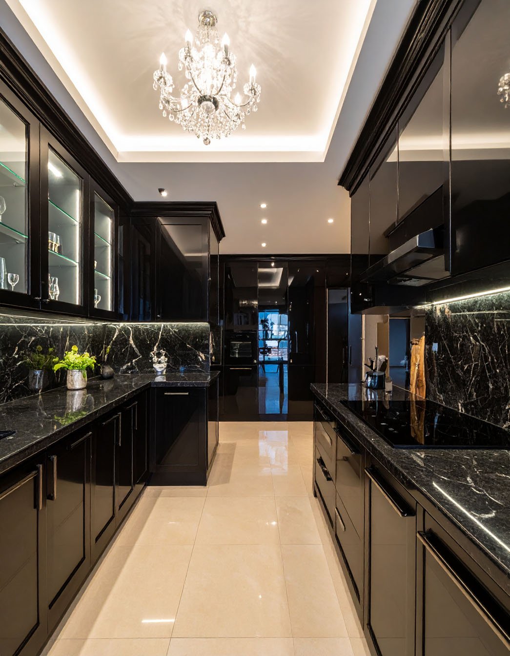 Cuisine luxueuse noire avec plans de travail en marbre noir et lustre en cristal