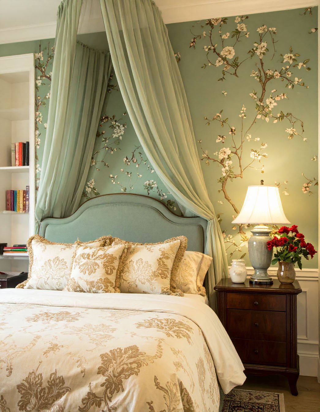 Chambre romantique avec lit à ciel de lit vert d'eau et papier peint floral assorti