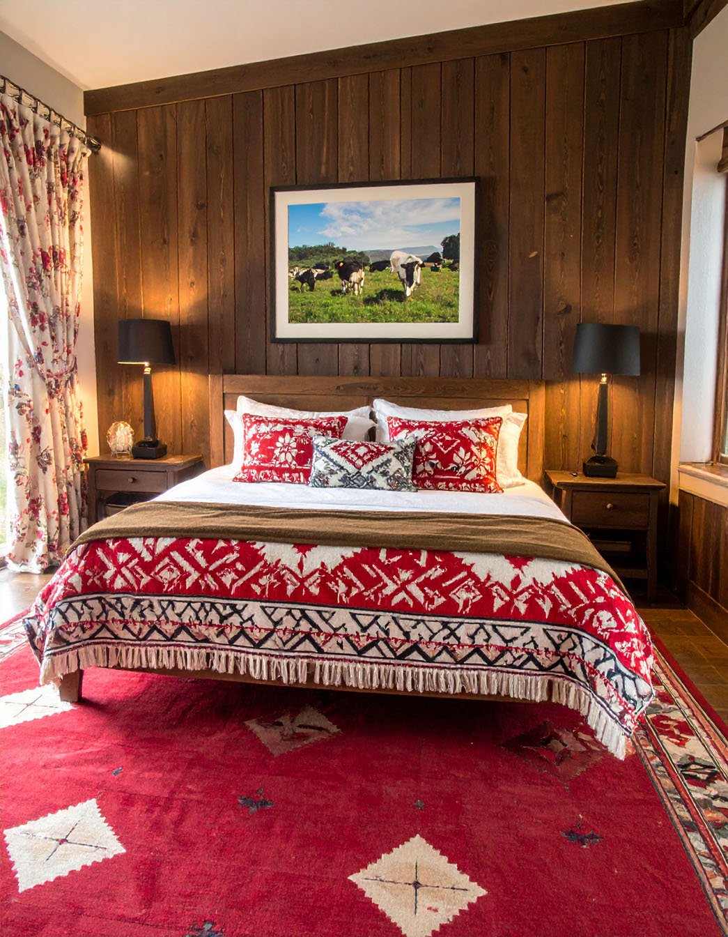 Chambre rustique avec lit en bois, couvre-lit à motifs indiens et mur en briques
