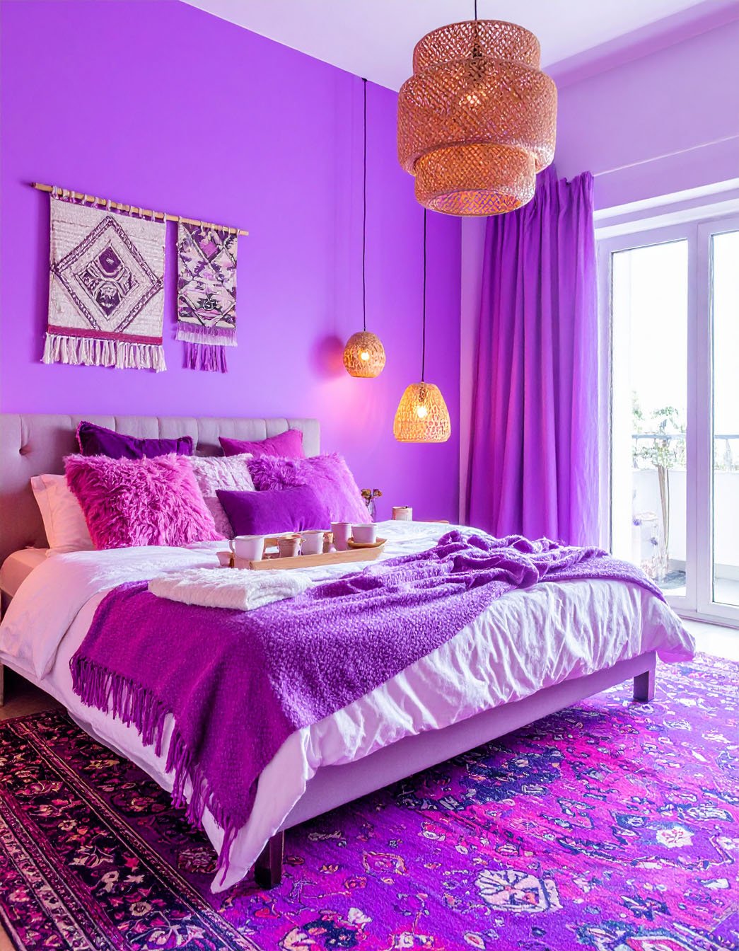 Chambre sombre avec murs bleu marine, lit en bois et literie à motifs violets et bleus