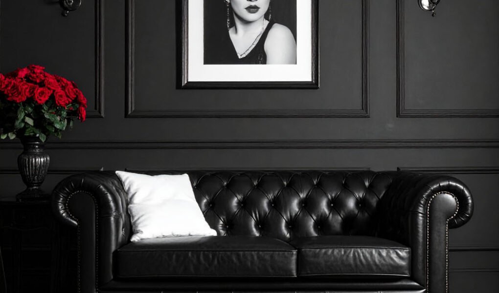 Salon avec murs gris, canapé Chesterfield en cuir noir et tapis à motifs graphiques