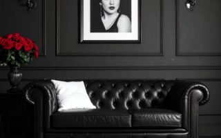 Salon avec murs gris, canapé Chesterfield en cuir noir et tapis à motifs graphiques