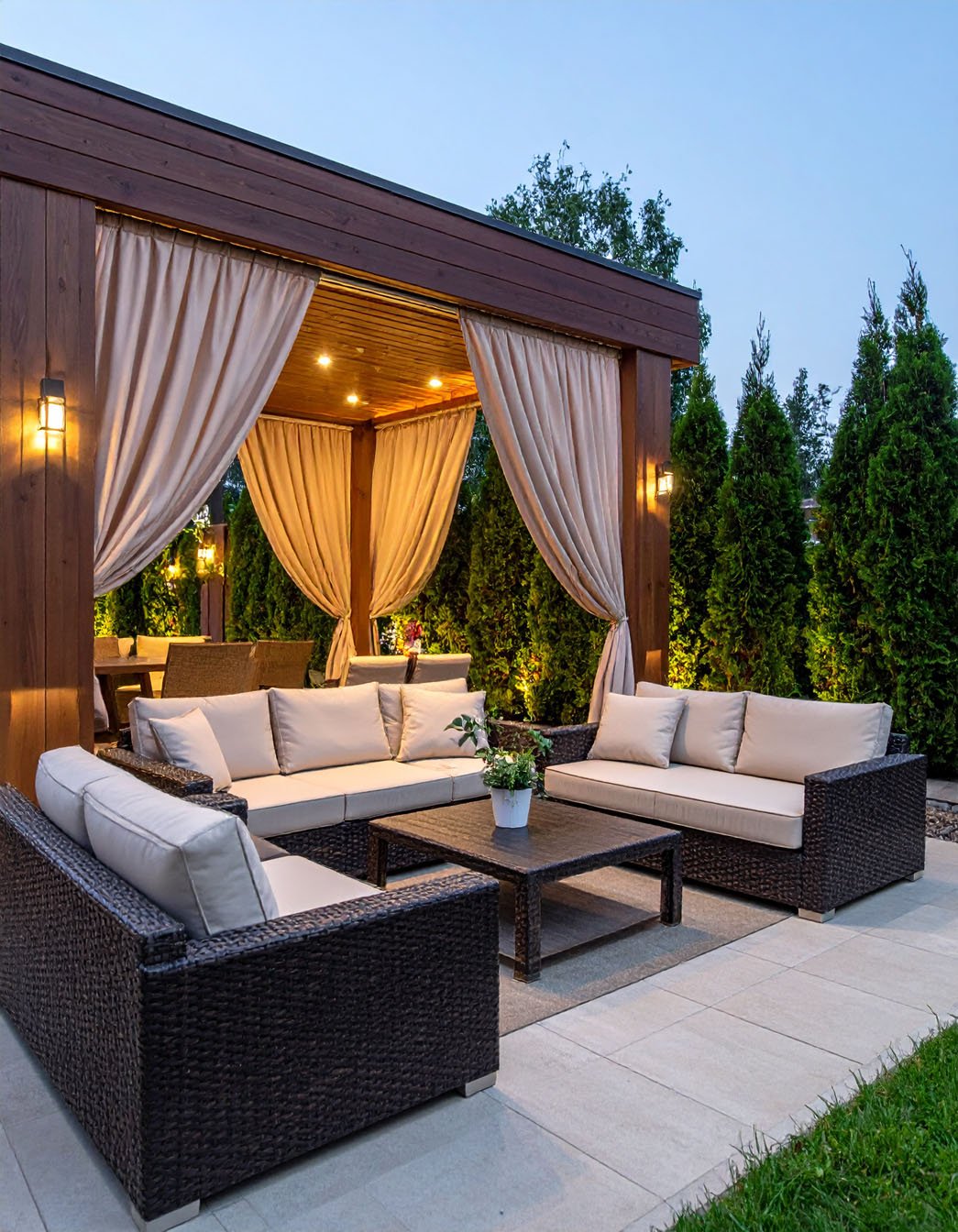 Terrasse de soirée avec salon de jardin en résine tressée et gazebo à rideaux