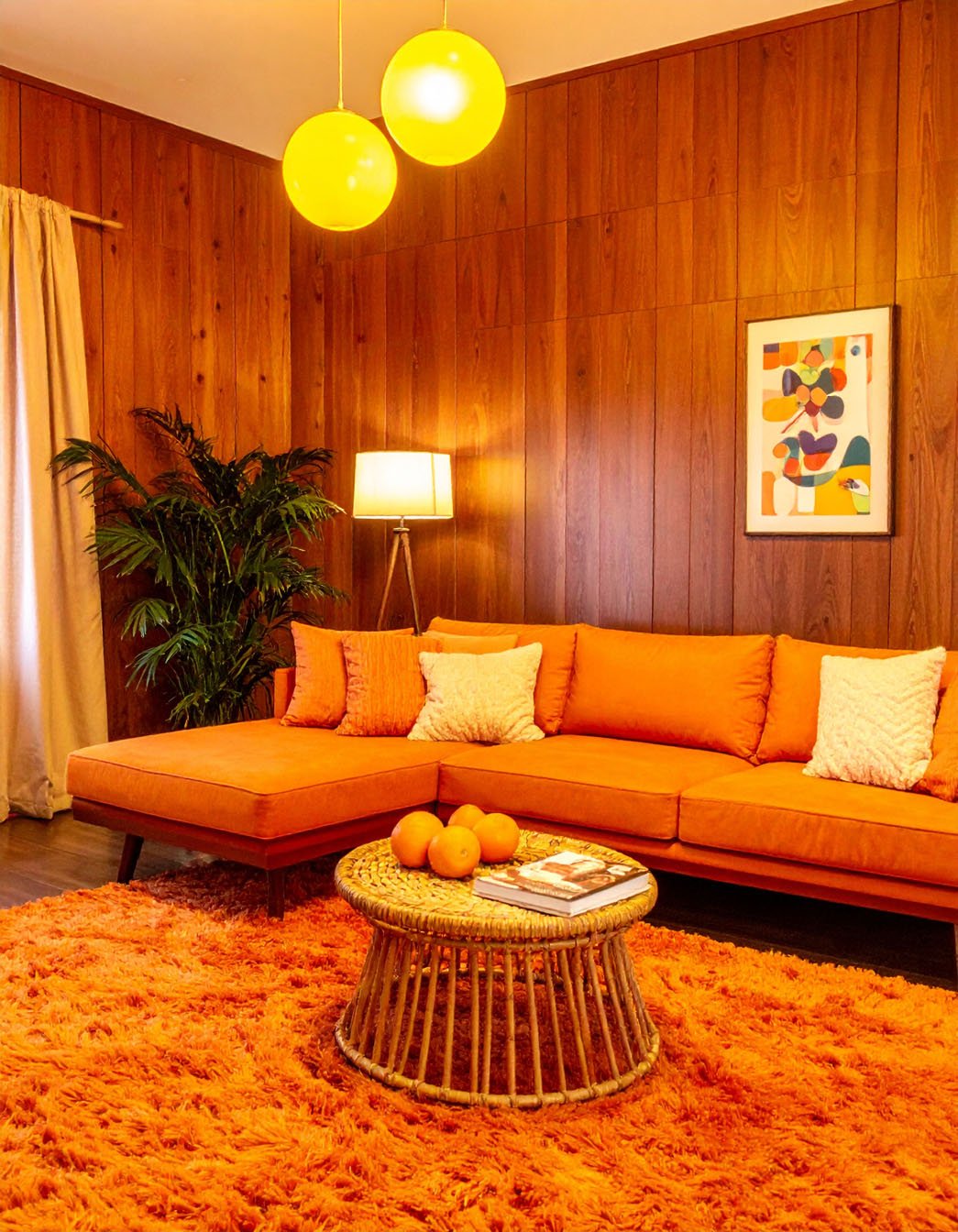 Salon rétro avec lambris en bois, canapé d'angle orange et tapis shaggy orange