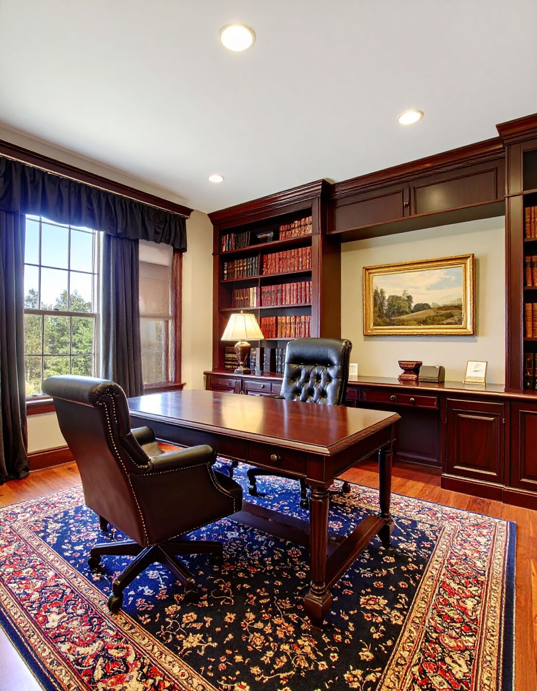 Bureau classique avec murs bordeaux, bureau en bois et bibliothèque intégrée
