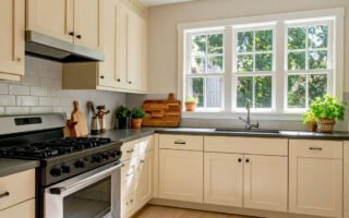 Cuisine avec meubles couleur crème, plan de travail foncé et tapis à motifs