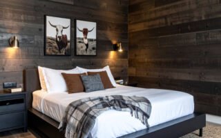 Chambre avec lit en bois, murs en planches de bois et tapis à motifs