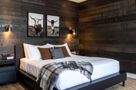 Chambre avec lit en bois, murs en planches de bois et tapis à motifs
