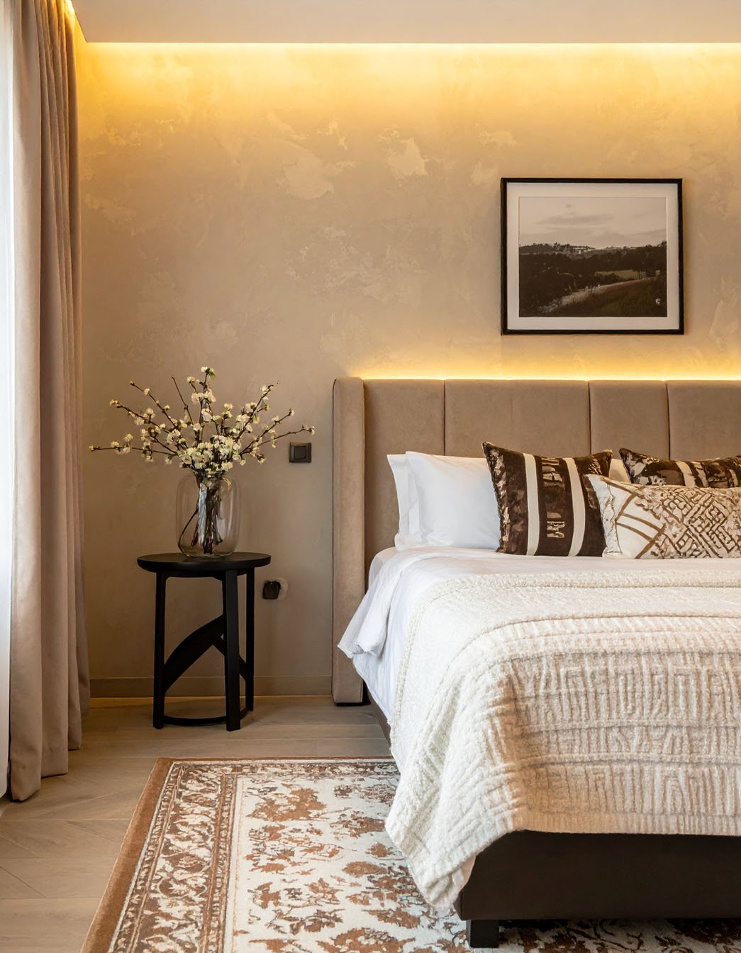 Chambre élégante avec tête de lit haute, éclairage indirect et tapis à motifs