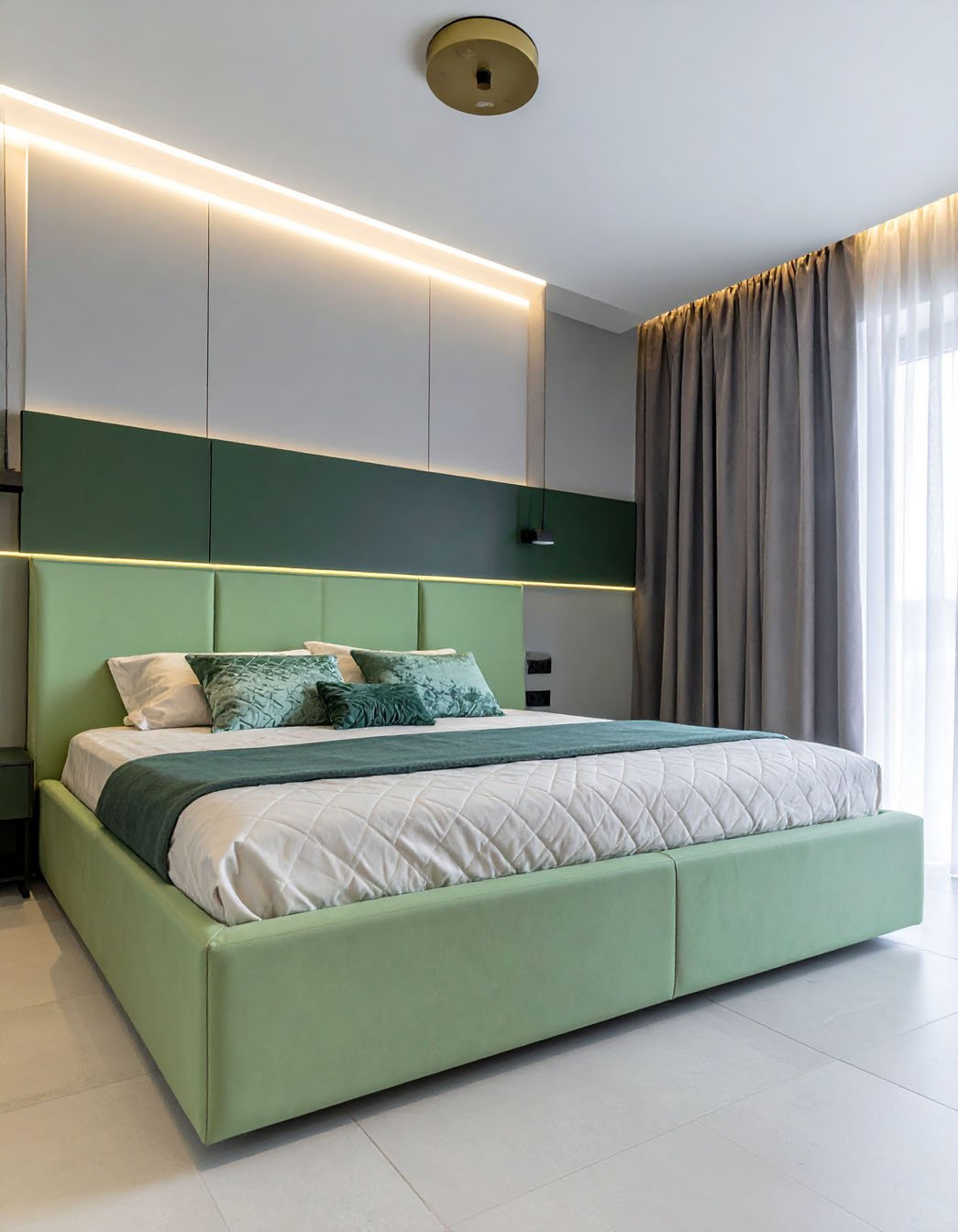 Chambre moderne avec grand lit vert clair, tête de lit haute et éclairage LED intégré