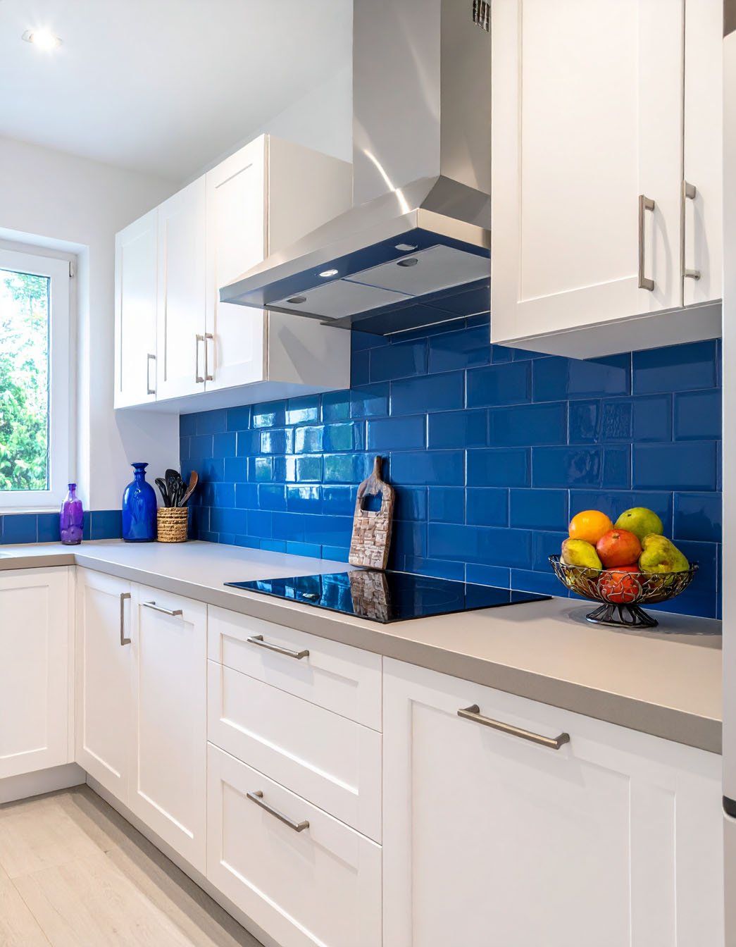 Cuisine blanche avec crédence en carreaux de métro bleu vif et plaque à induction