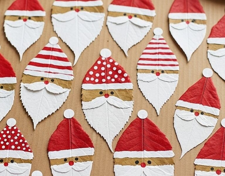 Bricolage de pères noël peints sur des feuilles d arbres rouges et blanches
