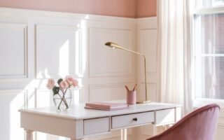 Bureau blanc avec chaise en velours rose dans une pièce aux murs roses