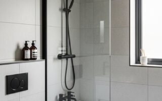 Salle de bain sobre avec carrelage gris et robinetterie noire mate