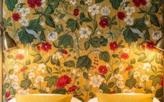 Tete de lit vintage recouverte d un tissu jaune a motifs de fleurs rouges